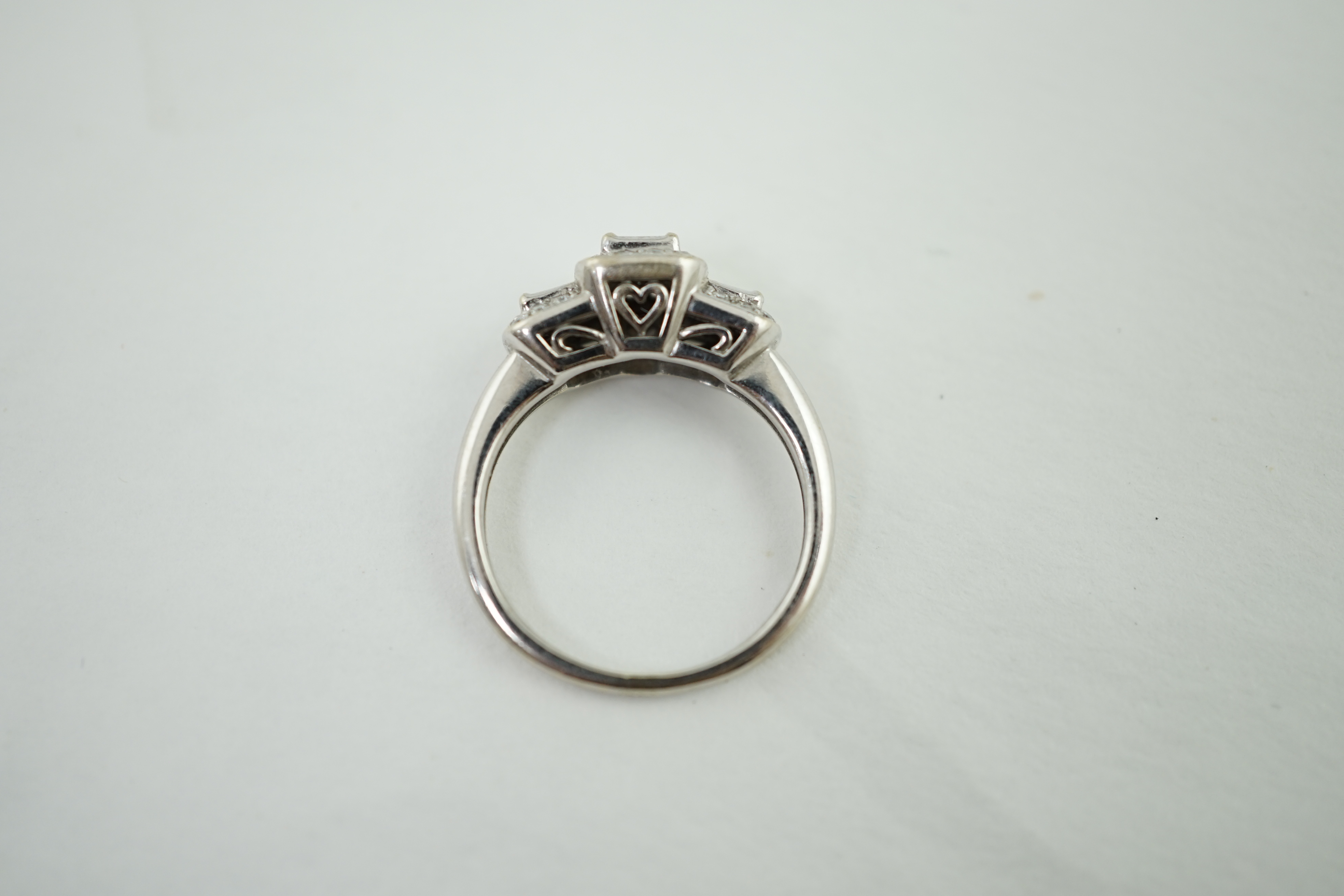 A modern white gold and diamond stepped triple cluster dress ring